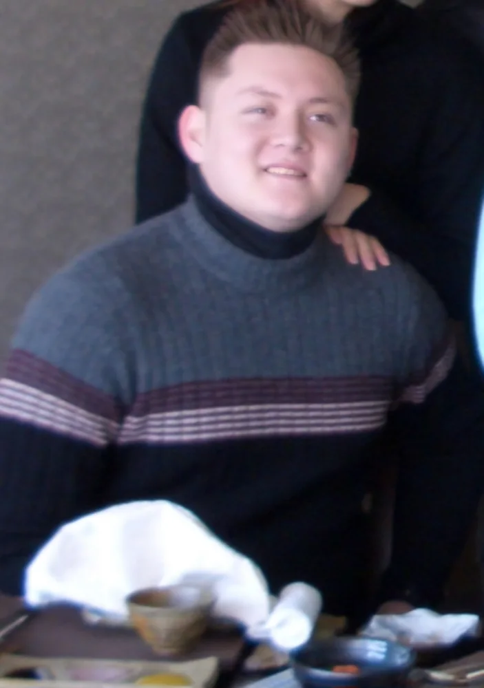 Art earlier in his journey, wearing a dark sweater with red stripes.